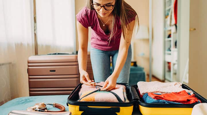 Woman packing vitamins in her luggage