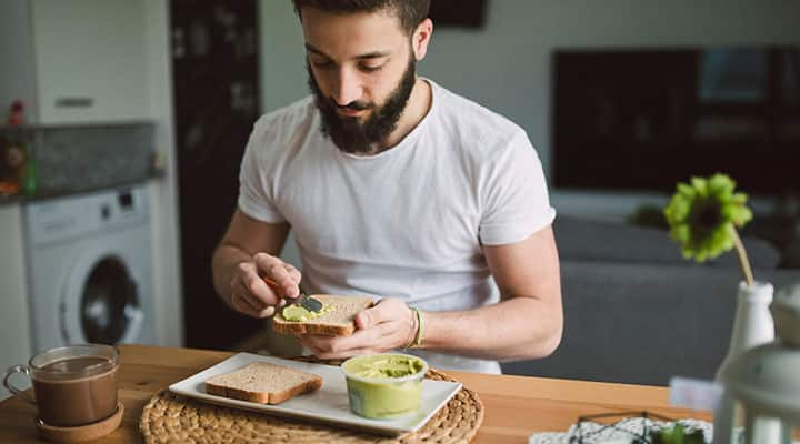 Man making and eating breakfast