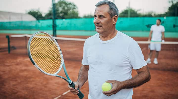 Older man playing tenis as an exercise  to help burn body fat