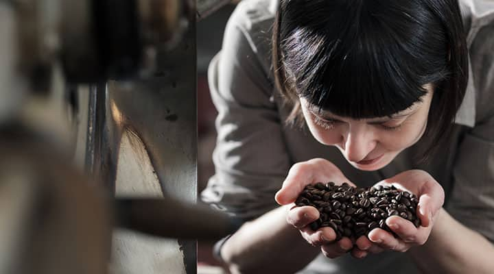 A woman smelling coffee beans