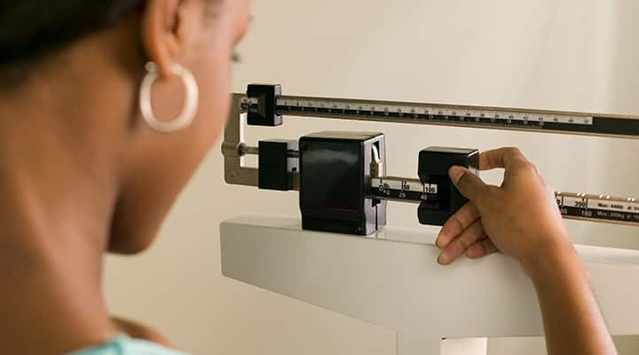 Woman measures weight on doctor's scale