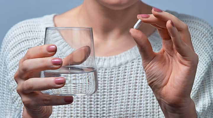 Woman supplements with probiotics