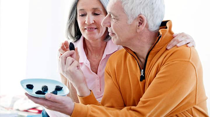 Older couple eating prunes which are good for aging bones