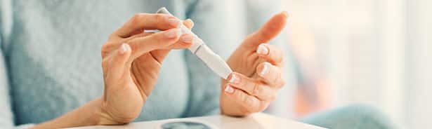 Woman taking blood to measure blood sugar levels