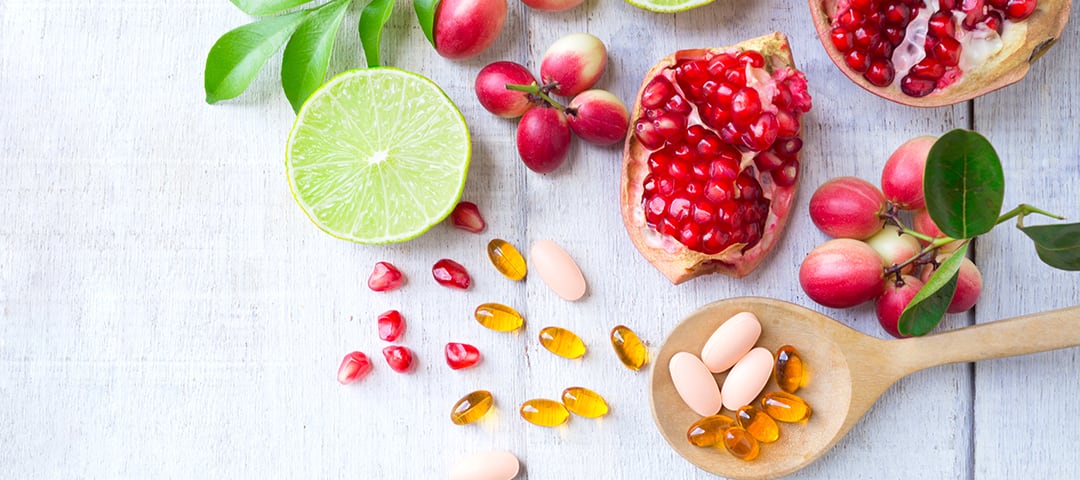Vitamins and food on wooden table