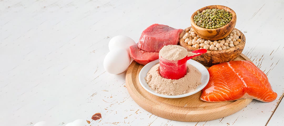 Salmon, nuts, seeds and other foods on wooden plate on table