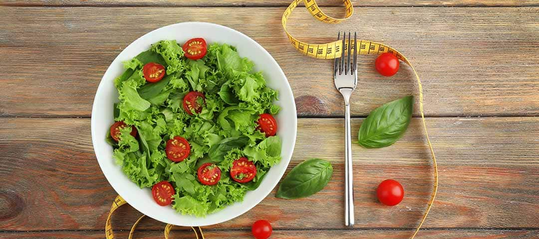 Bowl of Salad on wood table cutting calories