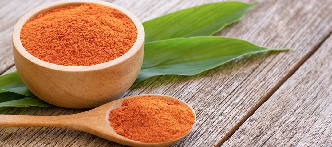 Curcumin in bowl and in spoon on wood table