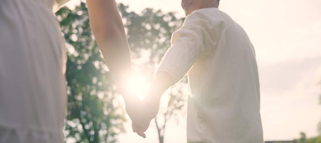 Man and woman holding hands in sun