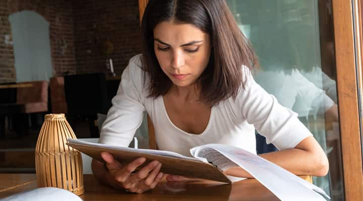 Woman pointing to a gluten-free food on a restaurant menu