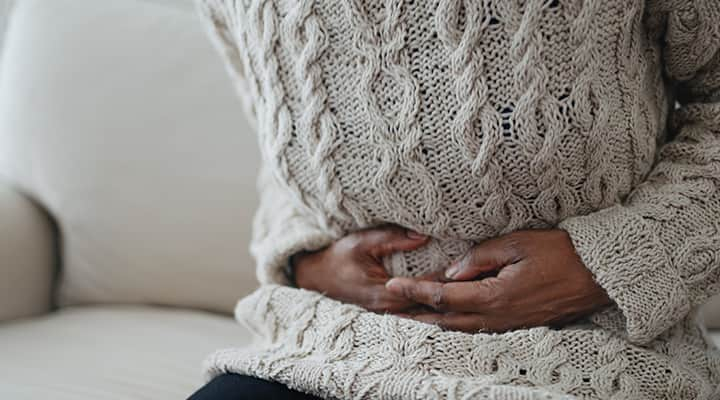 Woman with indigestion from eating foods containing antinutrients