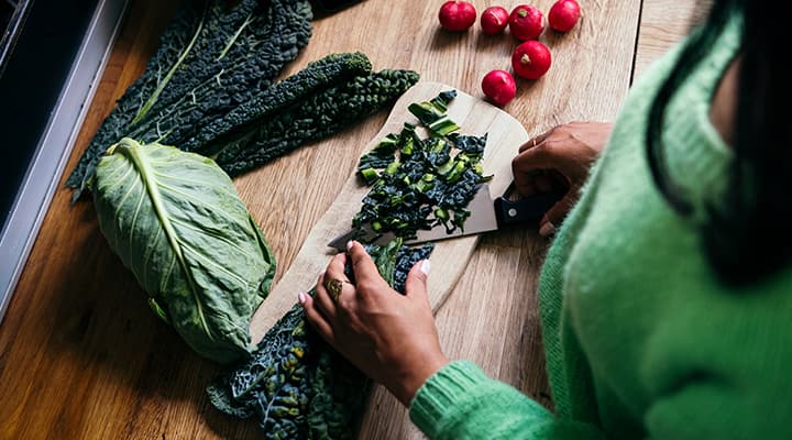 Woman chopping kale that contains goitrogens