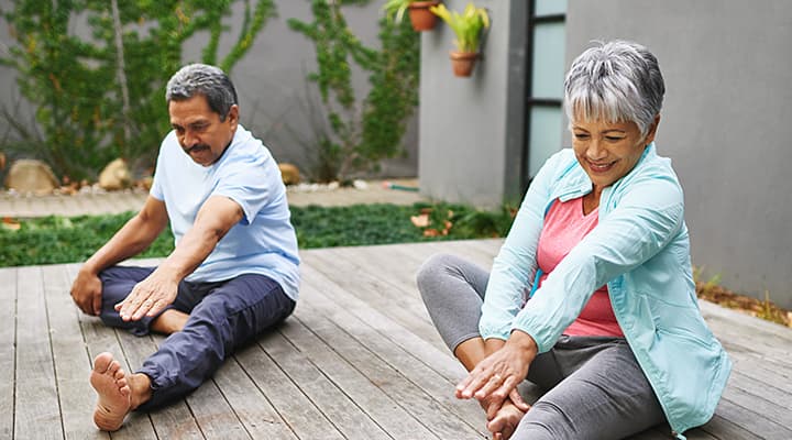 Elderly couple stretching at home