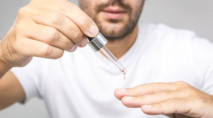 Man applying cuticle oil to his hands