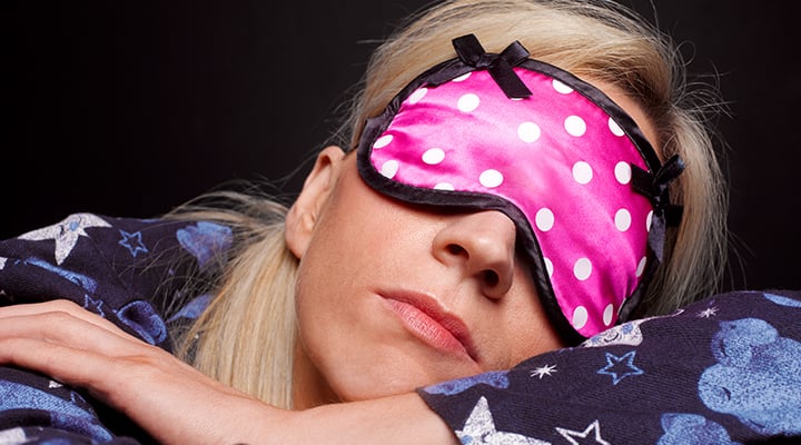 Woman wearing a sleep mask to reduce light when sleeping