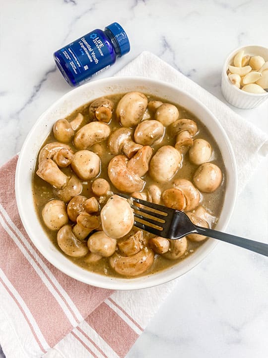 Bowl of sautéed mushrooms full of amino acids which support longevity at the cellular level