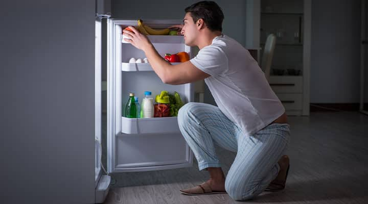 Man looking for food in refrigerator as a late-night snack