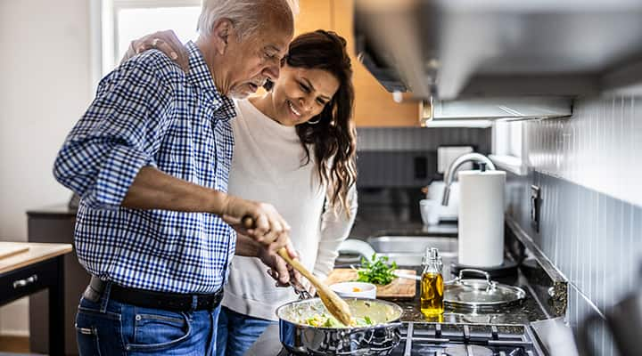 Man and woman cooking with olive oil at the stove