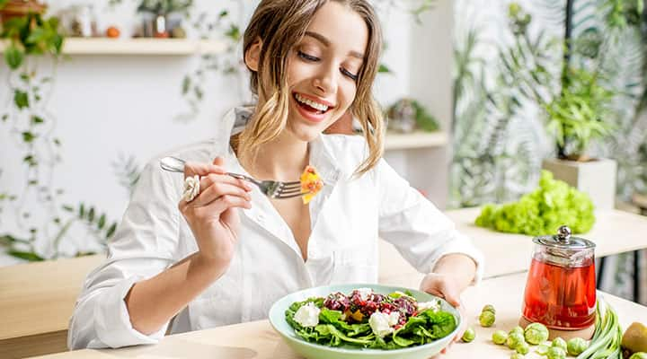 Woman eating greens and healthy fats for healthy mind