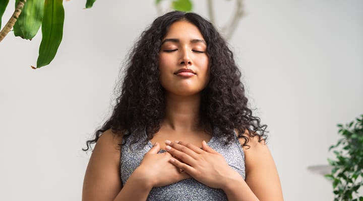 Woman meditating with her hands on her heart