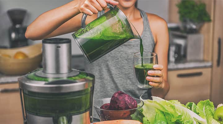 Woman making smoothie with chlorophyll dense foods