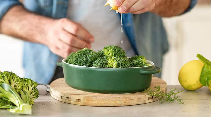 Man preparing broccoli which is rich in chlorophyll