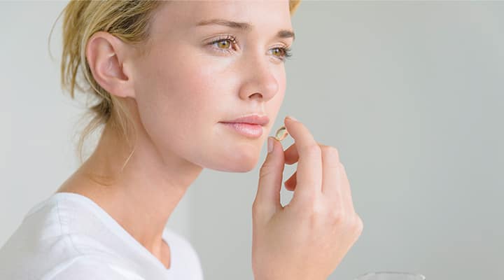 Woman taking supplement containing lutein and zeaxanthin for eye support