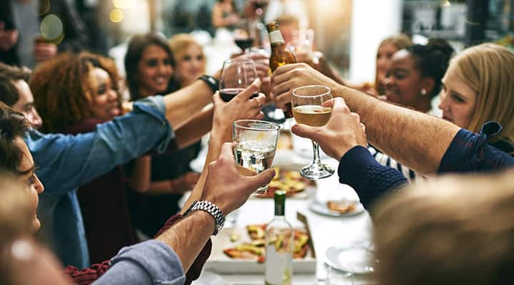 A group of friends toasting drinks, hoping they won't become hungover