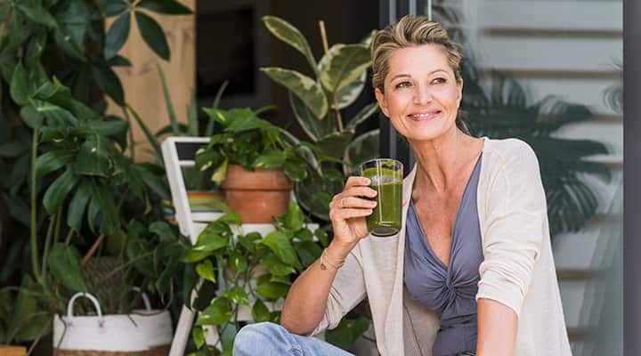 Healthy woman avoiding a hangover with a fresh green drink