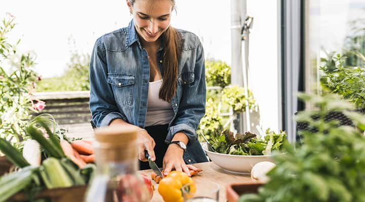 Vegetarian woman cutting vegetables