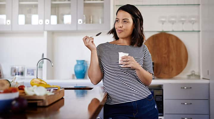 Woman with incorporated appetite-suppressing food into her diet eating yogurt