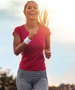 Woman jogging and laughing outside