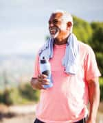 Man standing in the park holding a water bottle