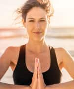 Woman doing yoga on the beach