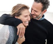 couple smiling while walking on the beach