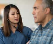 Nurse taking heart rate of patient 