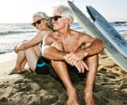 Older couple on beach with surf boards