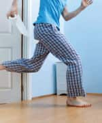 Man running to bathroom with toilet paper