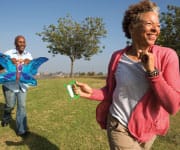 Older couple exercising in park with a kite