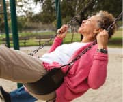 Older woman enjoying swing set with husband