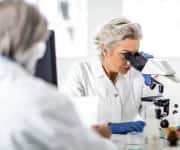 Lab technician using microscope for the vaginosis profile