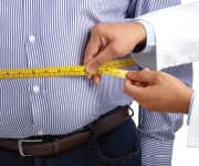 Man having doctor measuring waist after post-meal