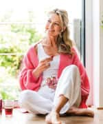 Smiling woman eating on the floor in comfort