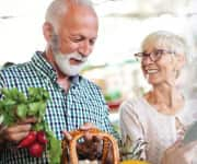 Mature couple shopping for vegetables with health-promoting nutrients