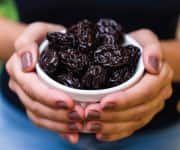 Dried plums in bowl that can be used for plum extracts