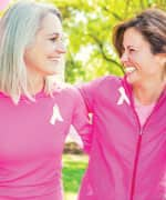 Two woman wearing pink ribbons who are survivors