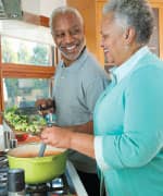 Older couple cooking with broccoli for beneficial compounds