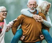 Older husband giving wife piggy-back ride with health benefits from vitamin K