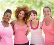 Four woman wearing pink and pink ribbons for breast cancer awareness