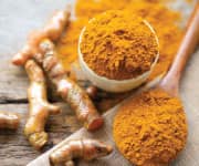 Whole and ground turmeric in bowl with biologically active compound curcumin